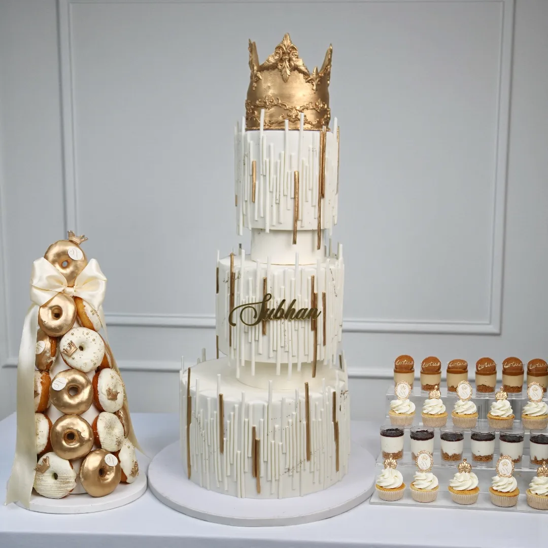 White and gold statement birthday cake with matching desserts