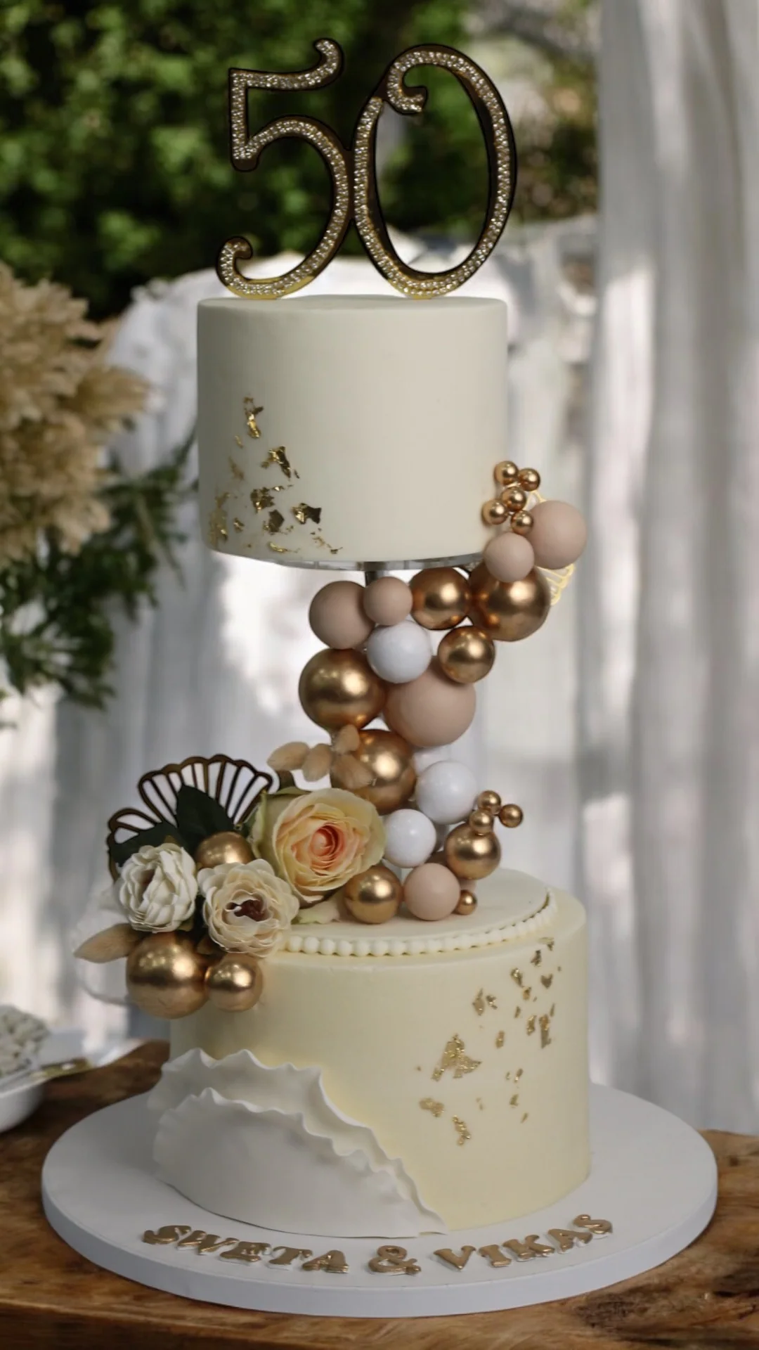 Elegant 50th anniversary cake with gold, ivory and floral details