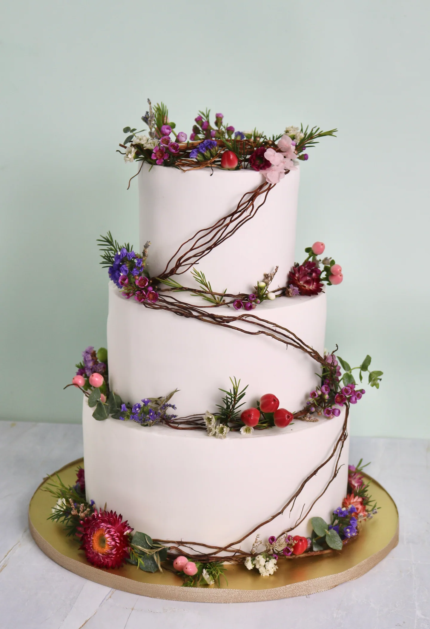 Three-tier floral anniversary cake with delicate branches and flowers