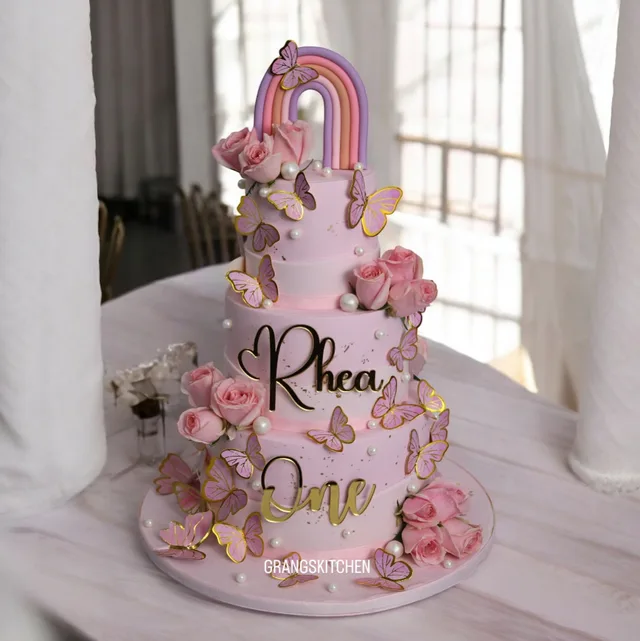Pink butterfly birthday cake with roses and rainbow topper