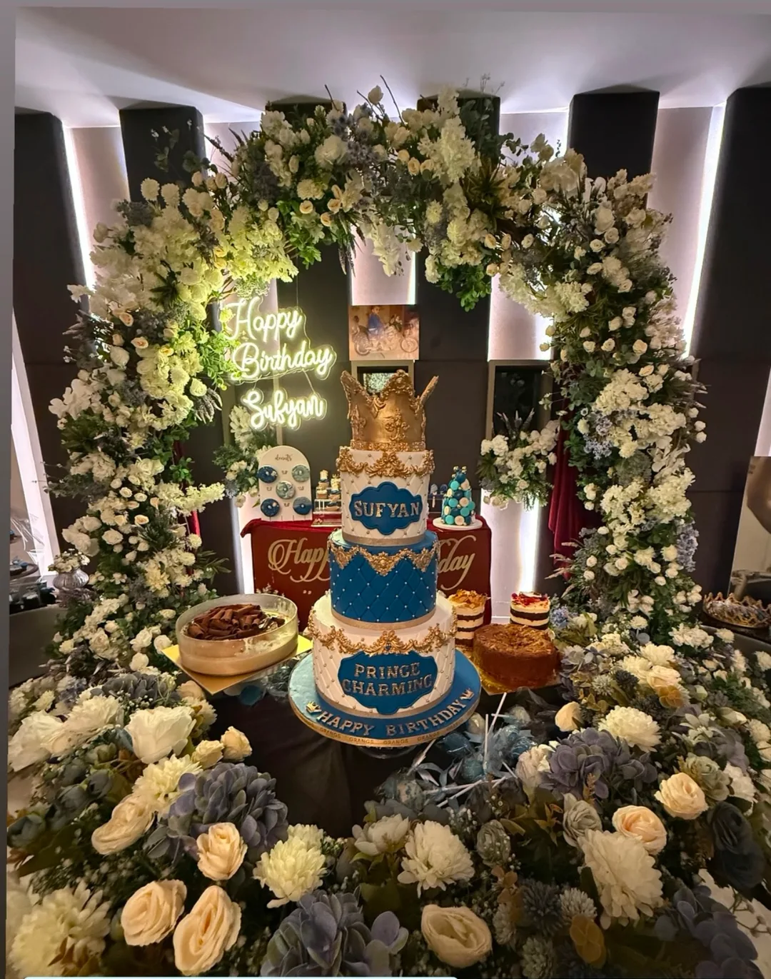 Blue and gold Sufyan birthday dessert setup with floral event decor