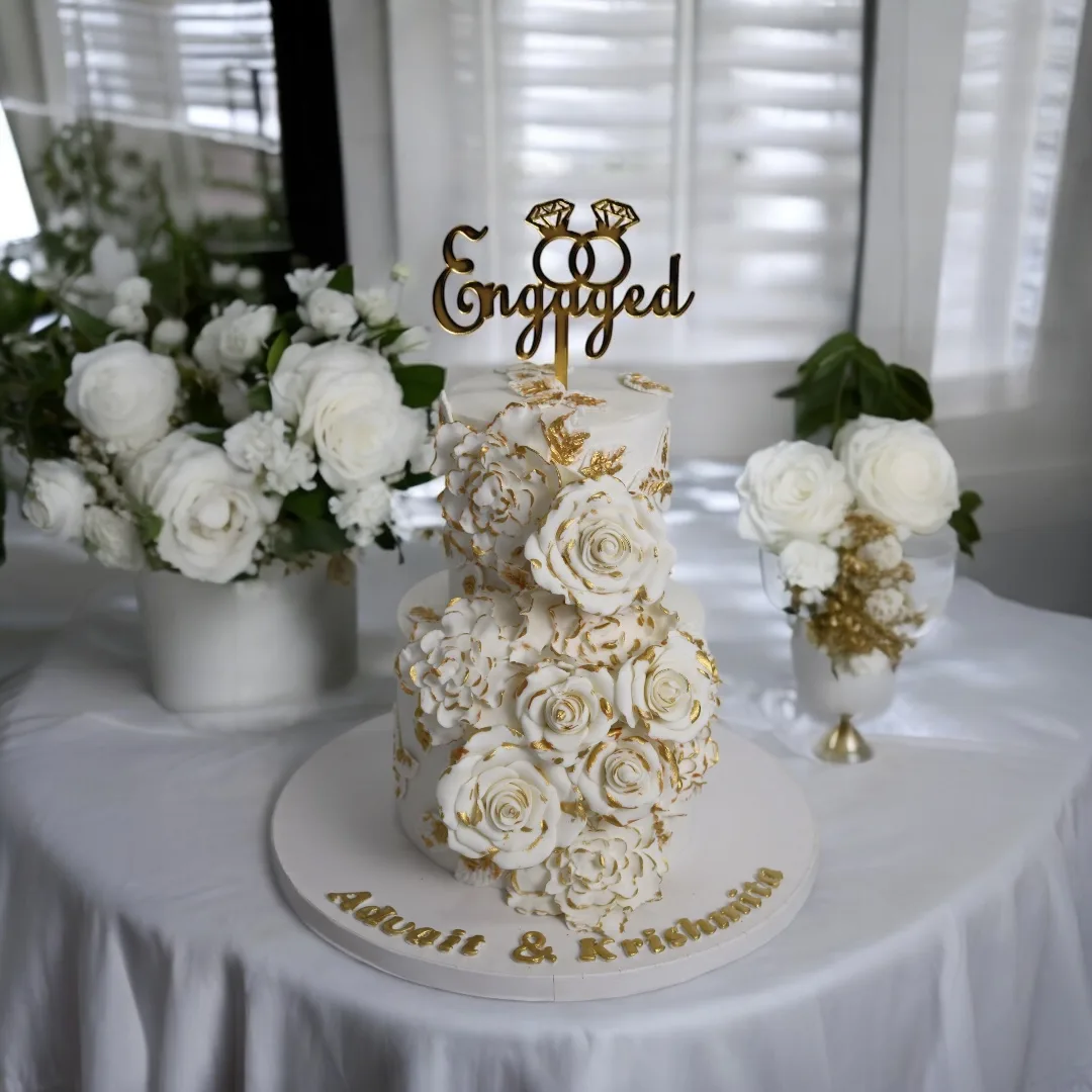 White and gold engagement cake with sugar flowers and ring topper