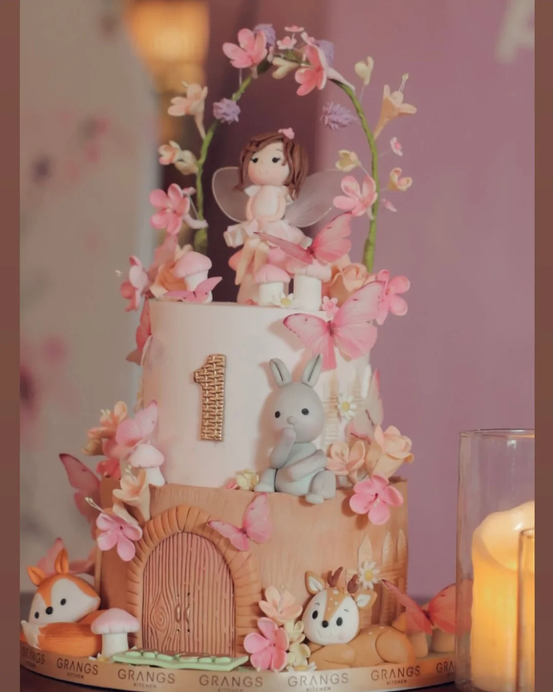 Fairy and butterfly themed first birthday cake in soft pink tones