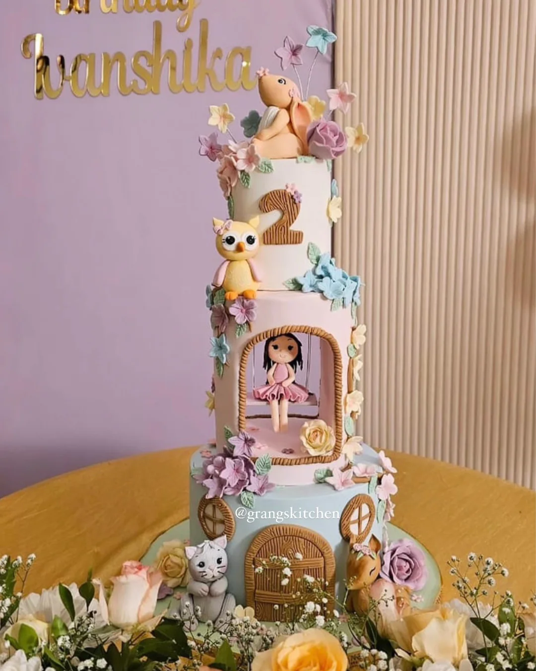 Woodland-themed first birthday cake with animals and floral details
