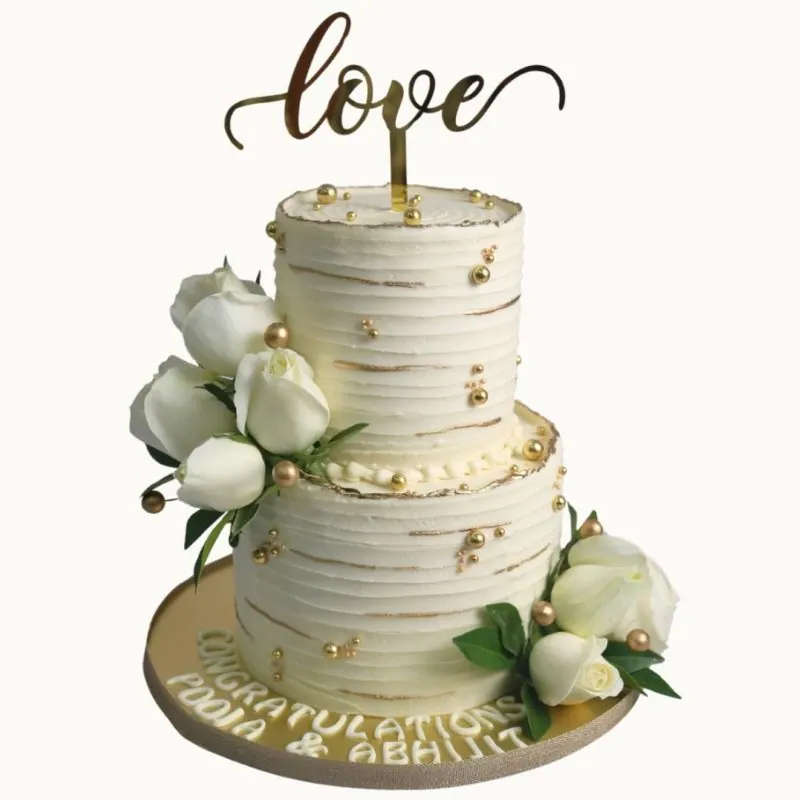 Elegant white cake with love topper and white florals