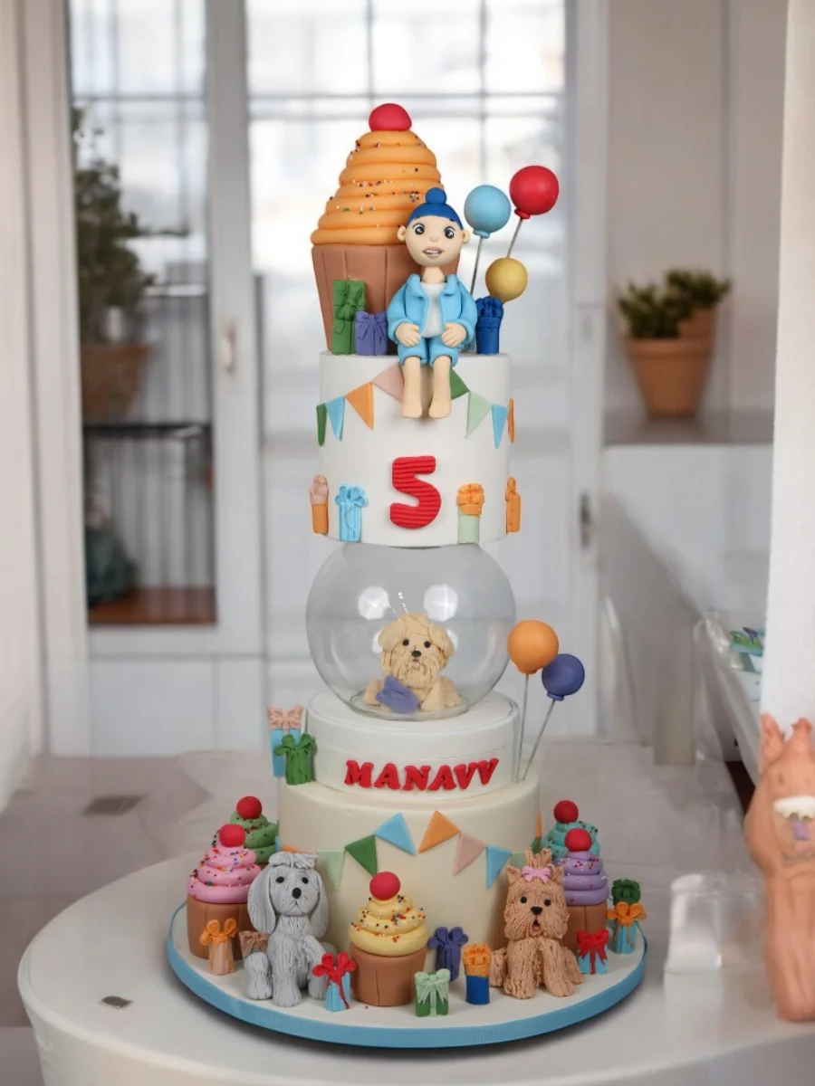 Playful fifth birthday cake with puppy and cupcake details