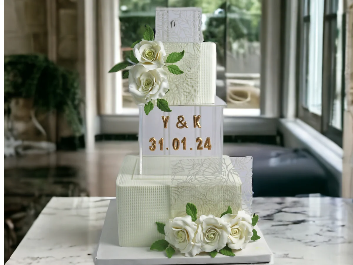White floral anniversary cake with gold initials