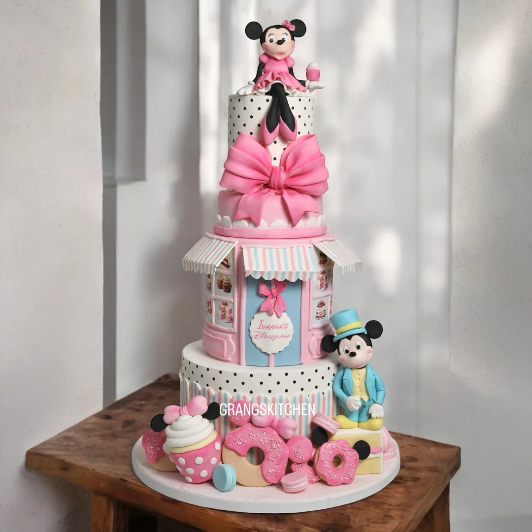 Pink character-themed birthday cake with bow and playful figures