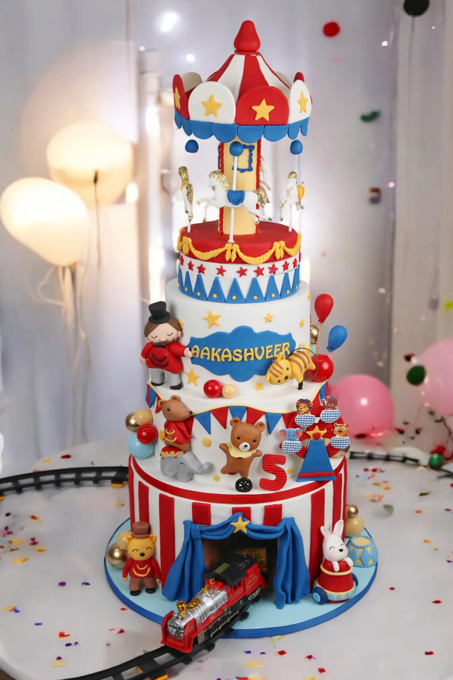 Tall circus carnival birthday cake with train and red-blue decorations