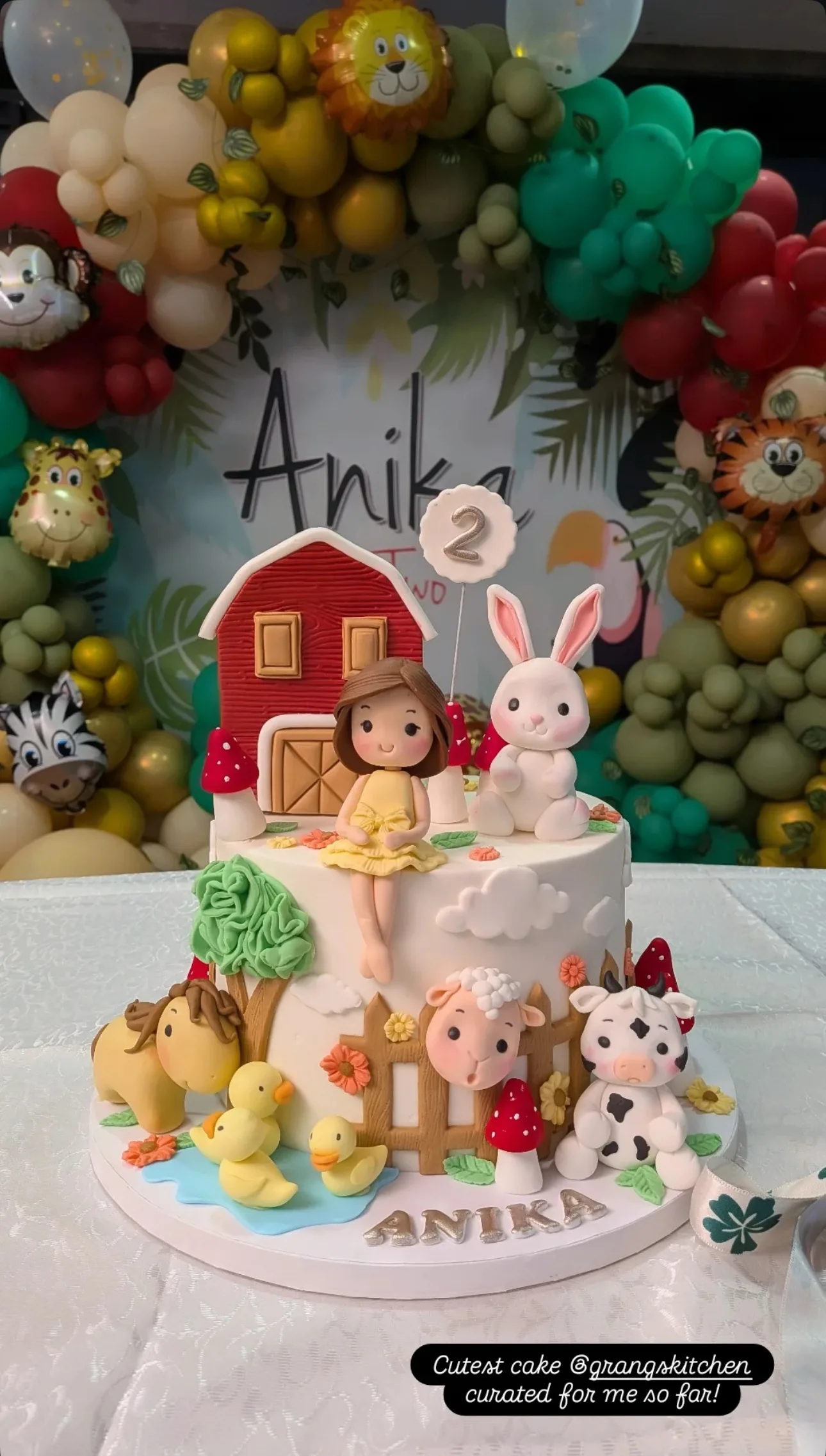 Farm theme birthday cake with barn, animals and balloon backdrop