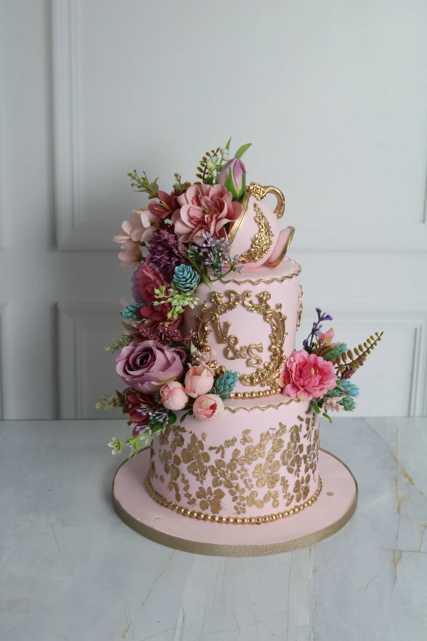 Pink and gold floral wedding cake with personalised initials